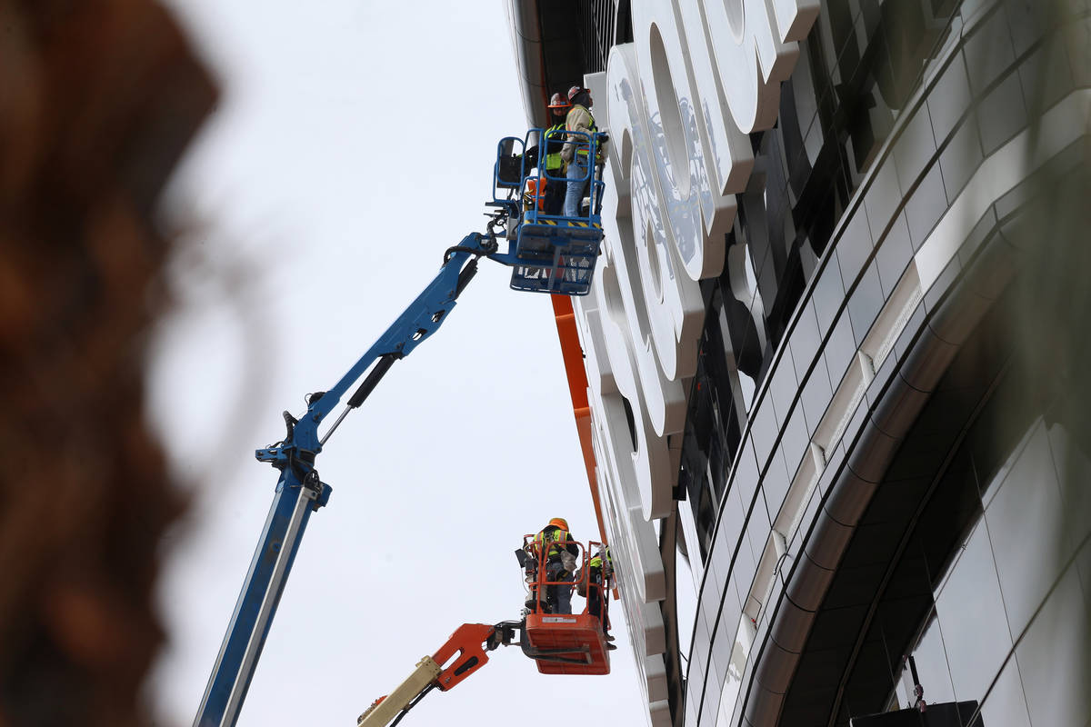 Workers inspect the Allegiant Stadium signage, in Las Vegas, Wednesday, March 18, 2020. (Erik V ...