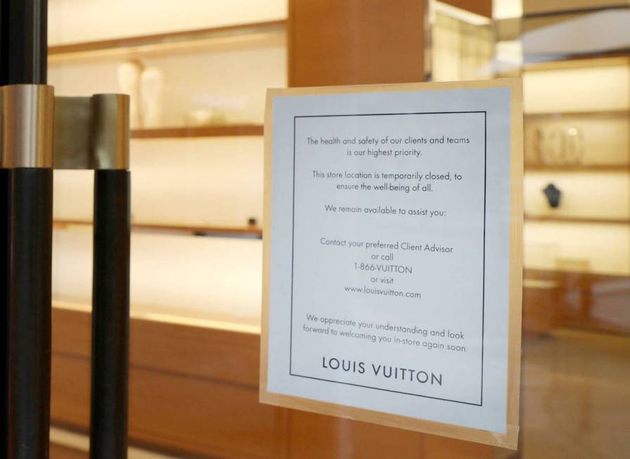 A sign hangs on the Louis Vuitton storefront informing the public the doors will be closed due ...