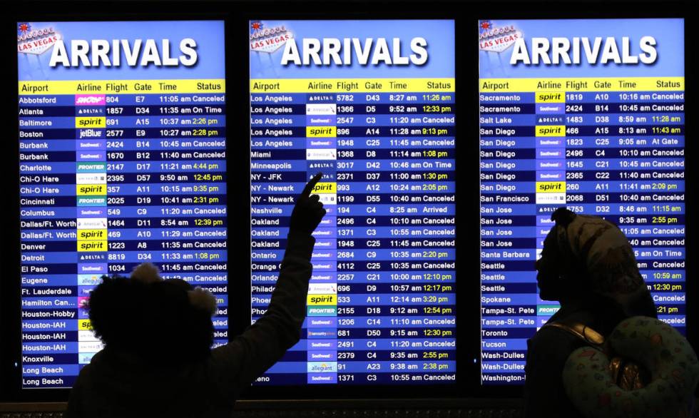 Baylee Williams, 11, left, and her sister Emiah, 12, both of Lousiana, check their cancelled fl ...