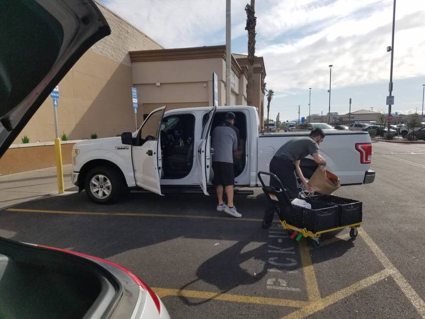 Smith's employee Jagger delivers a pickup order Thursday, March 19, 2020, in Henderson. (Heidi ...