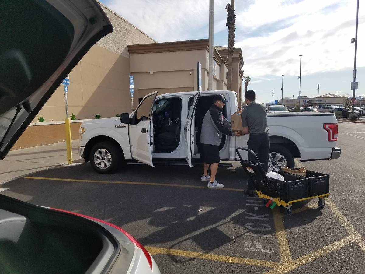 Smith's employee Jagger delivers a pickup order Thursday, March 19, 2020, in Henderson. (Heidi ...