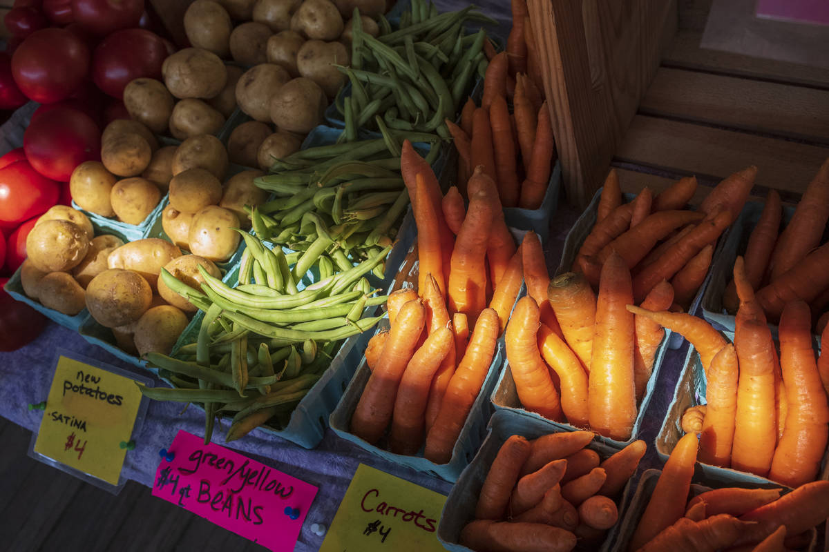 Fresh vegetables, carrots, green beans, potatoes and tomatoes, for sale at a farmers market sta ...