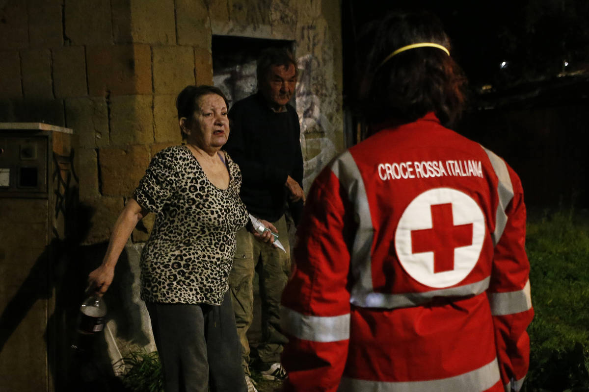 Red Cross volunteers bring food and disinfectants to homeless at Verano cemetery in Rome Saturd ...