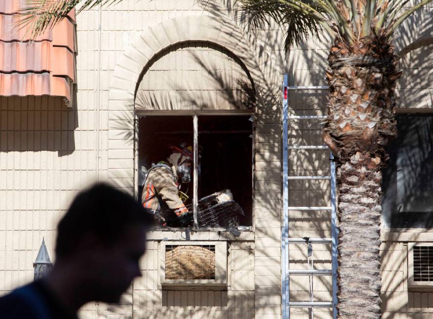 Las Vegas Fire Department firefighters assess the damage after structure fire was put out at 32 ...