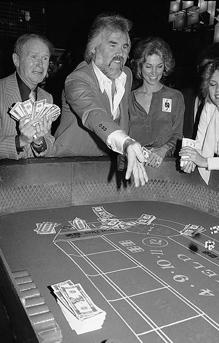 In this March 22, 1979 file photo, Kenny Rogers, center, rolls the dice at Regine's in New Yo ...