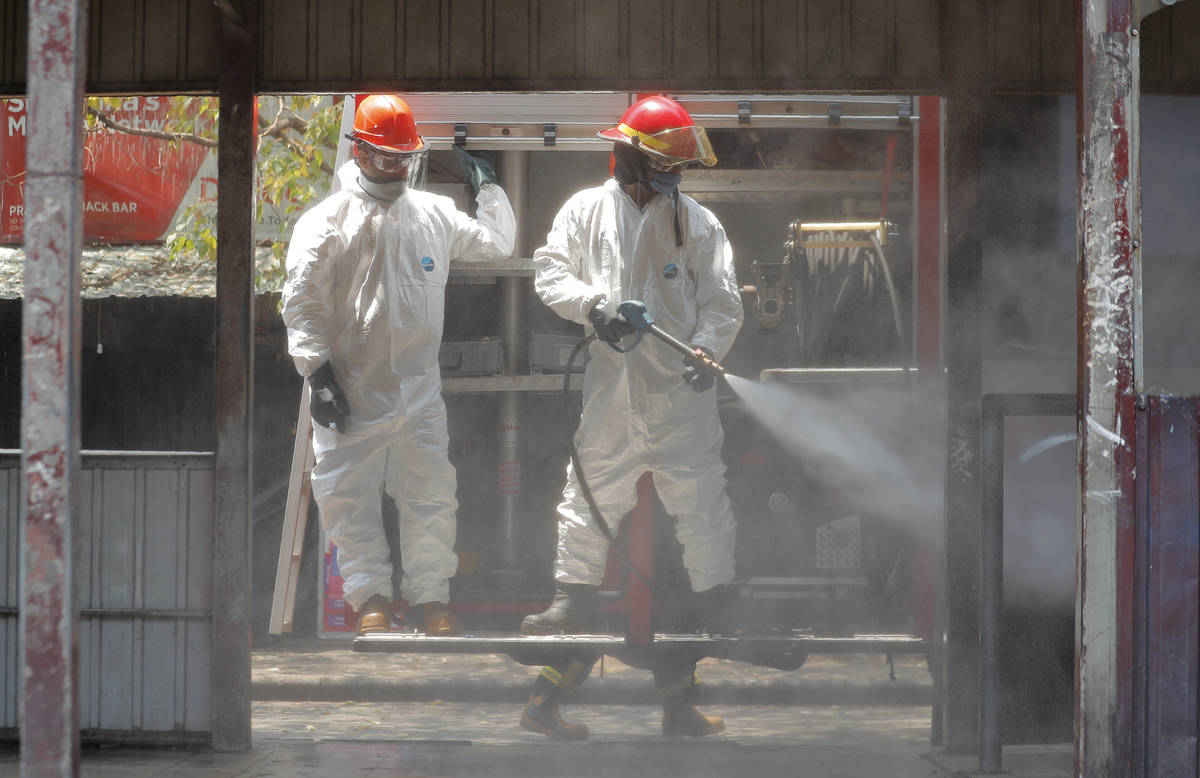Sri Lankan fire brigade personnel spray disinfectants at a bus terminal in Colombo, Sri Lanka, ...