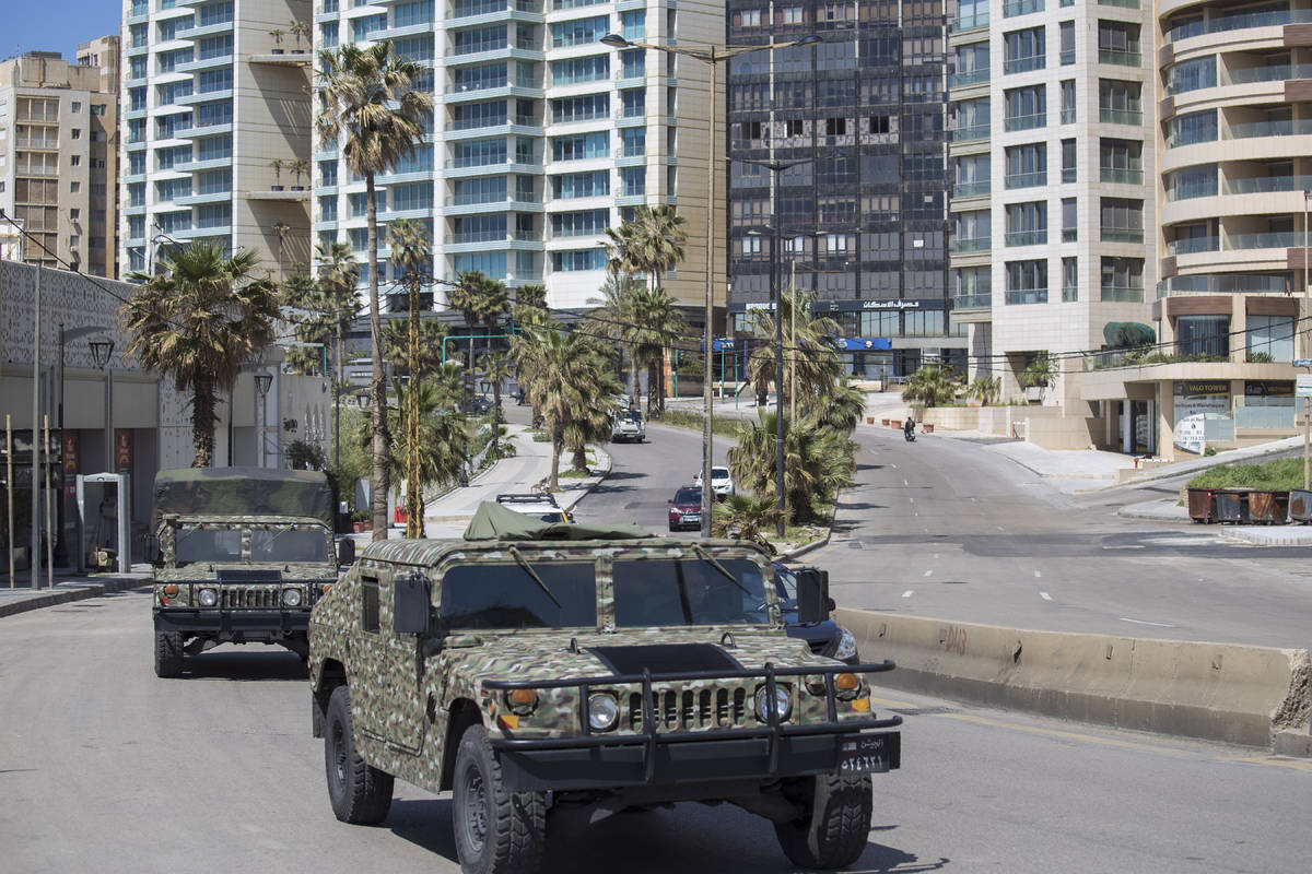 Lebanese army vehicles patrol the streets urging people to stay home unless they have to leave ...