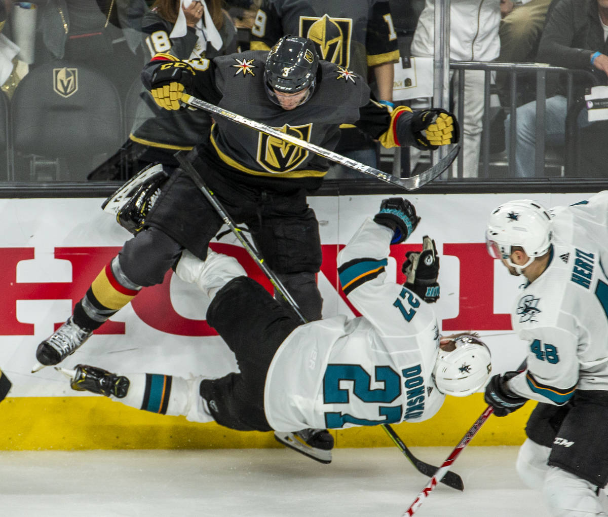 Golden Knights defenseman Brayden McNabb (3) puts a big hit on San Jose Sharks right wing Joona ...