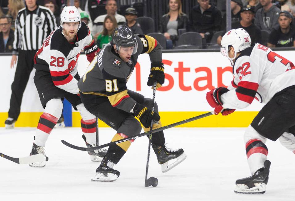 Vegas Golden Knights center Jonathan Marchessault (81) tries to skate around New Jersey Devils ...