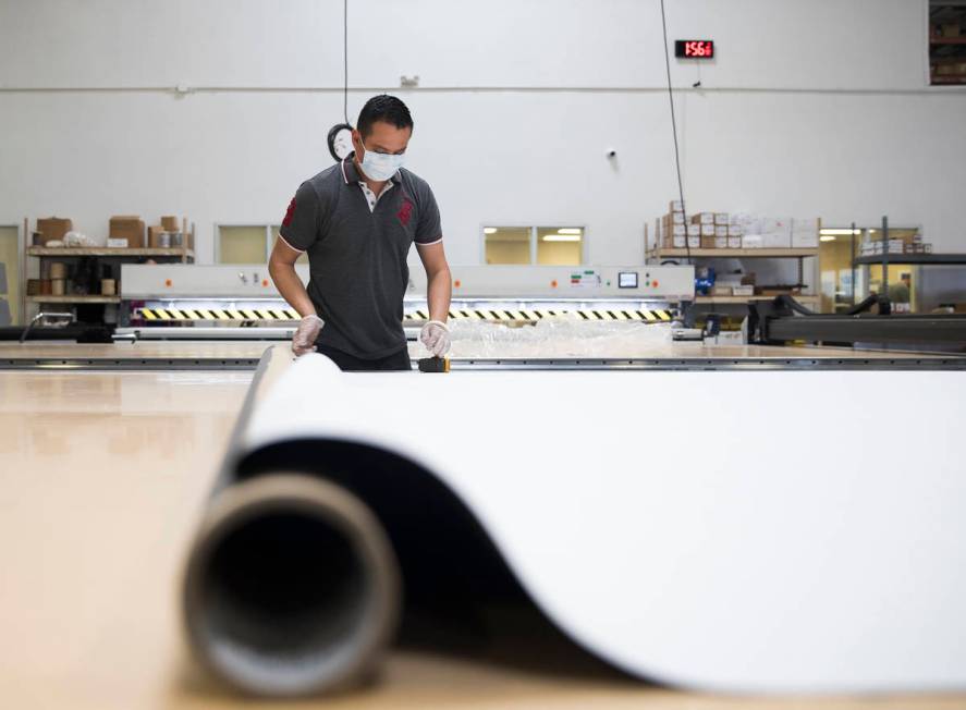 Nacho Villareal measures a roller shade to cut at Polar Shades in Las Vegas, Monday, March 23, ...