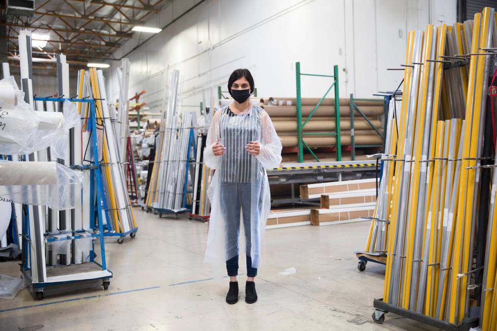 Employee Jordan Mevius wearing a gown and mask at Polar Shades in Las Vegas, Monday, March 23, ...