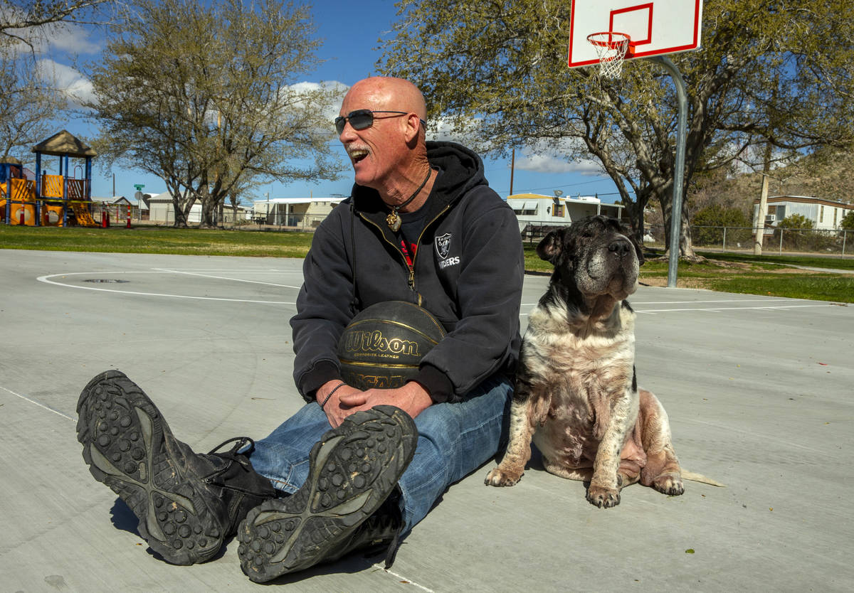 Searchlight resident Michael Howard takes a break from shooting some baskets with his dog Marth ...