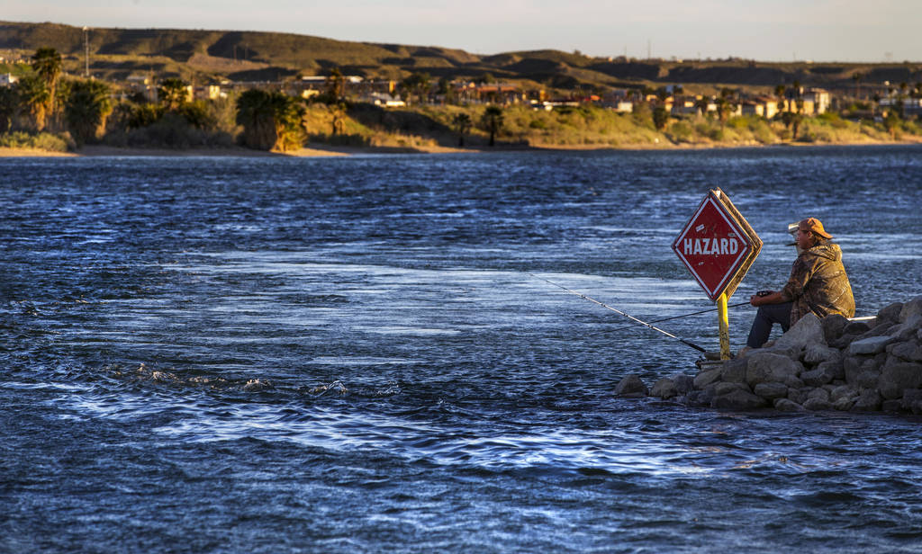 A man fishes in the Colorado River running beside Laughlin where the town is nearly shut down d ...