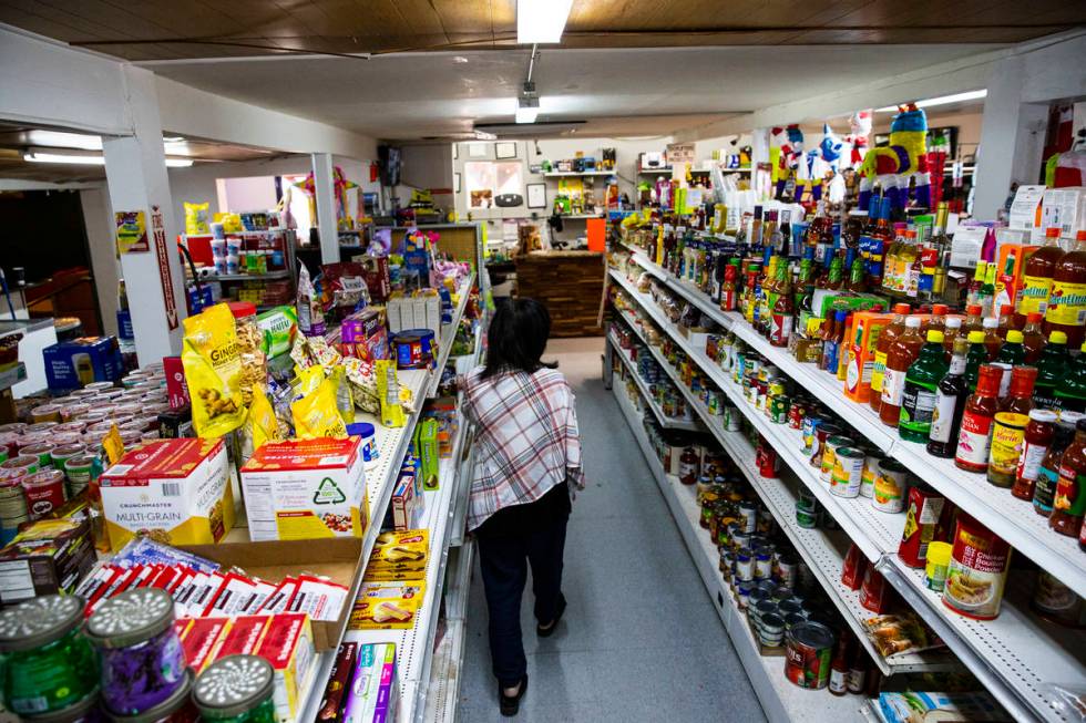 Sunny Martell, owner of Martell Market, walks through an aisle full of items stocked at the mar ...