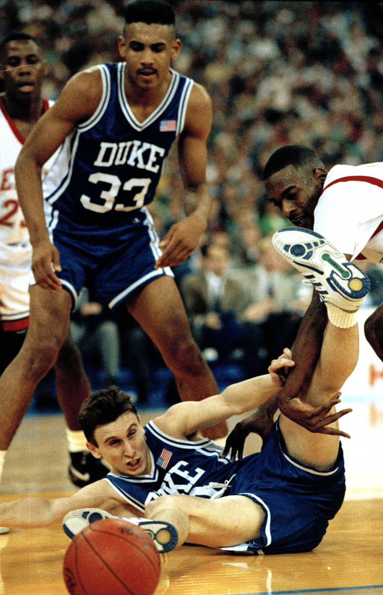 Duke's Bobby Hurley goes to the floor after the basketball as Stacey Augmon of UNLV, right, and ...