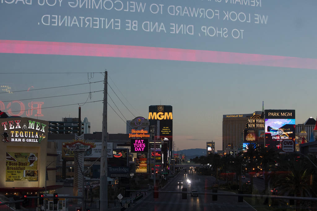 Lights turn on as the sun sets on the Strip on Tuesday, March 24, 2020, in Las Vegas. (Ellen Sc ...