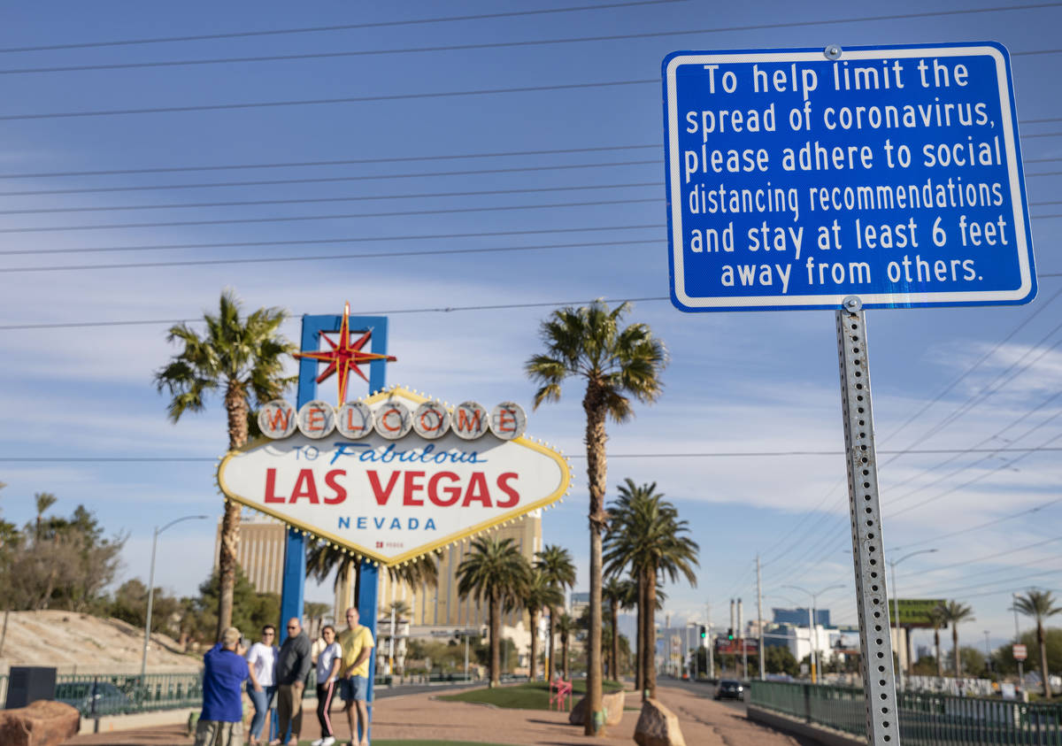 A sign is seen recommending social distancing as tourists from Sydney, Australia take photos un ...