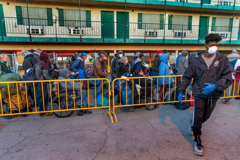 People line up at the Courtyard Homeless Resource Center to receive a sleeping mat for the nigh ...