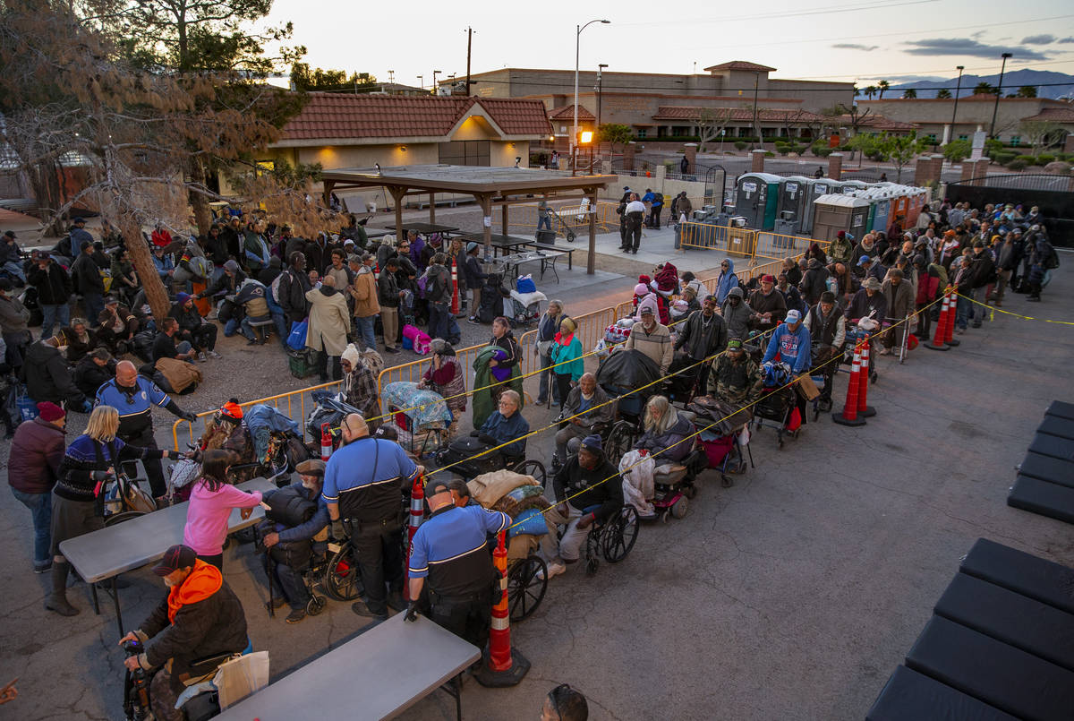 People line up at the Courtyard Homeless Resource Center to receive a sleeping mat for the nigh ...