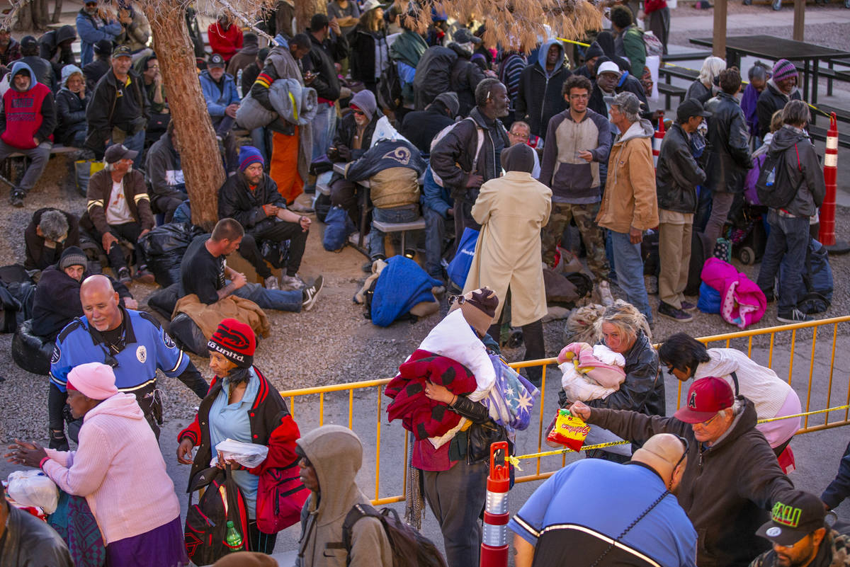 People receive a security check while in line at the Courtyard Homeless Resource Center to rece ...