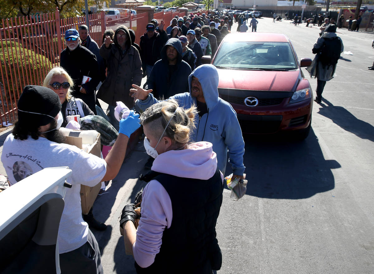 Joey Lankowski and Morgan Kozlowski of homeless outreach organization Food Not Bombs hand out b ...