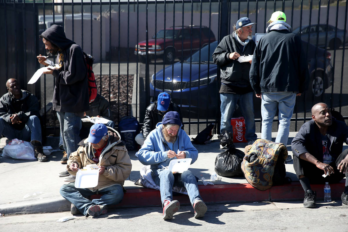 People eat to-go lunches from Catholic Charities on Foremaster Lane in Las Vegas Thursday, Marc ...