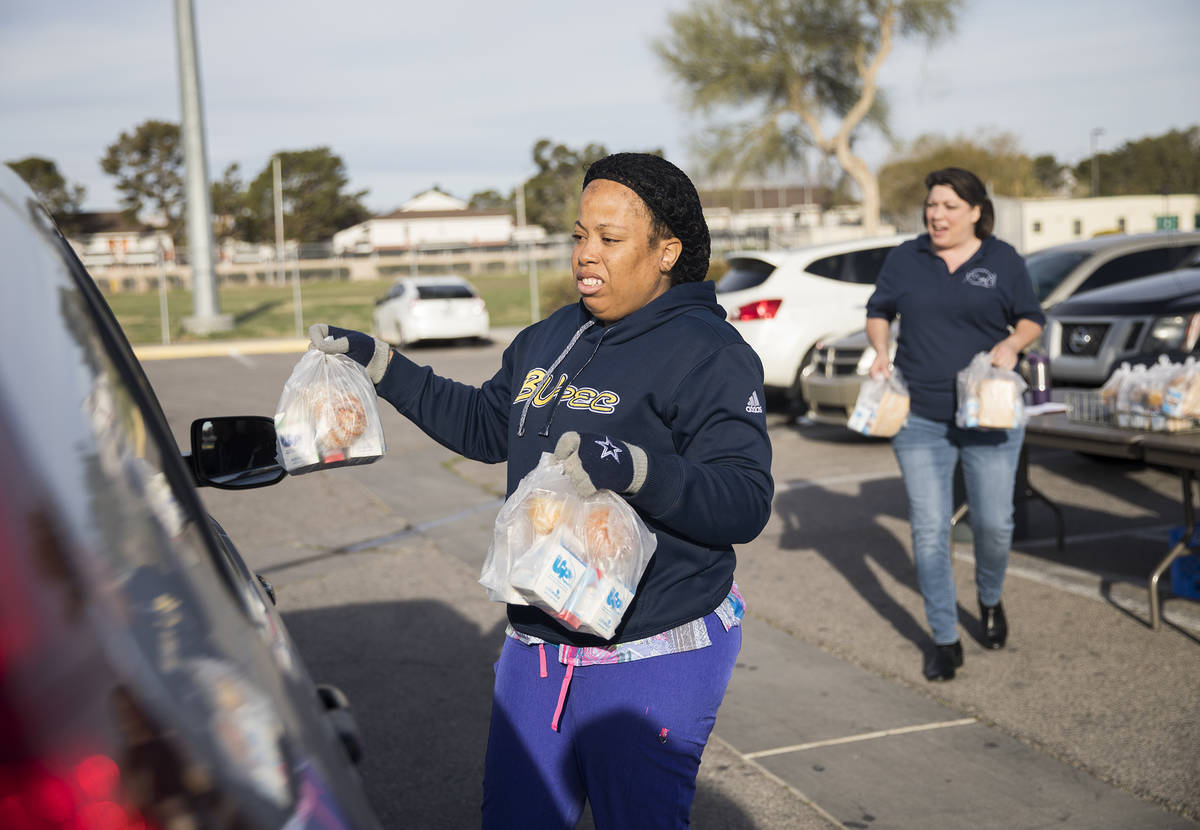 Clark County School District employees hand out breakfast and lunch packages to families at Cla ...