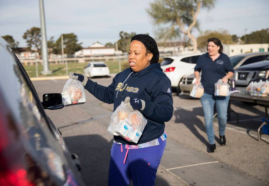 Clark County School District employees hand out breakfast and lunch packages to families at Cla ...