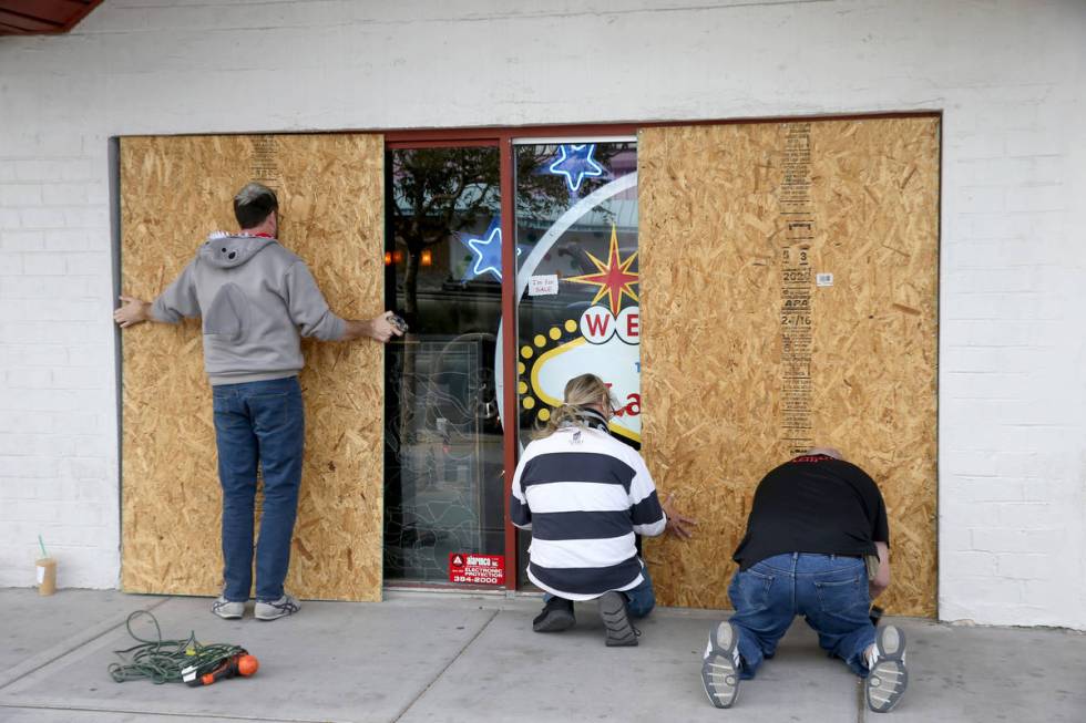 George Lovitt, owner of Antique Alley Mall on Main Street in downtown Las Vegas, right, covers ...