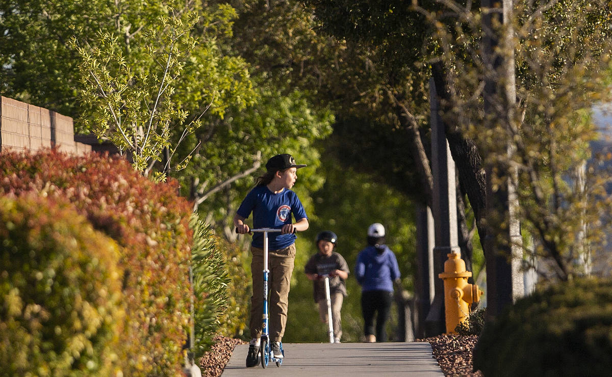 Children ride their scooters on North Hualapai Way on Friday, March 27, 2020, in Las Vegas. (Be ...