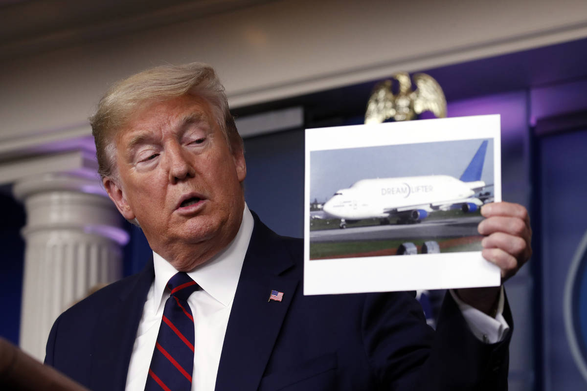 President Donald Trump holds up a photo of a Boeing Dreamlifter cargo airplane as he speaks abo ...