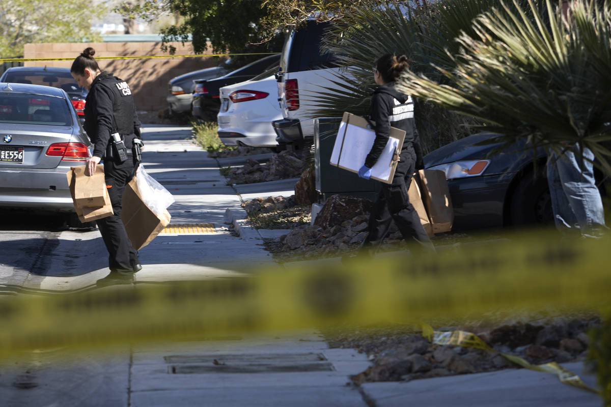 Members of Las Vegas police's crime scene investigative unit carry evidence out of the house wh ...