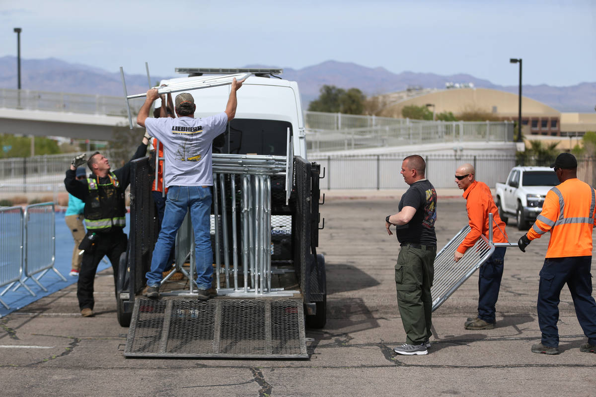 Volunteers set up barriers for a temporary homeless shelter at the Cashman Field parking lot in ...