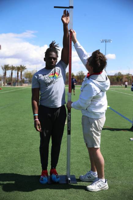 University of Hawai'i football graduate Ikem Okeke, left, gets his reach measured by Mike Weins ...