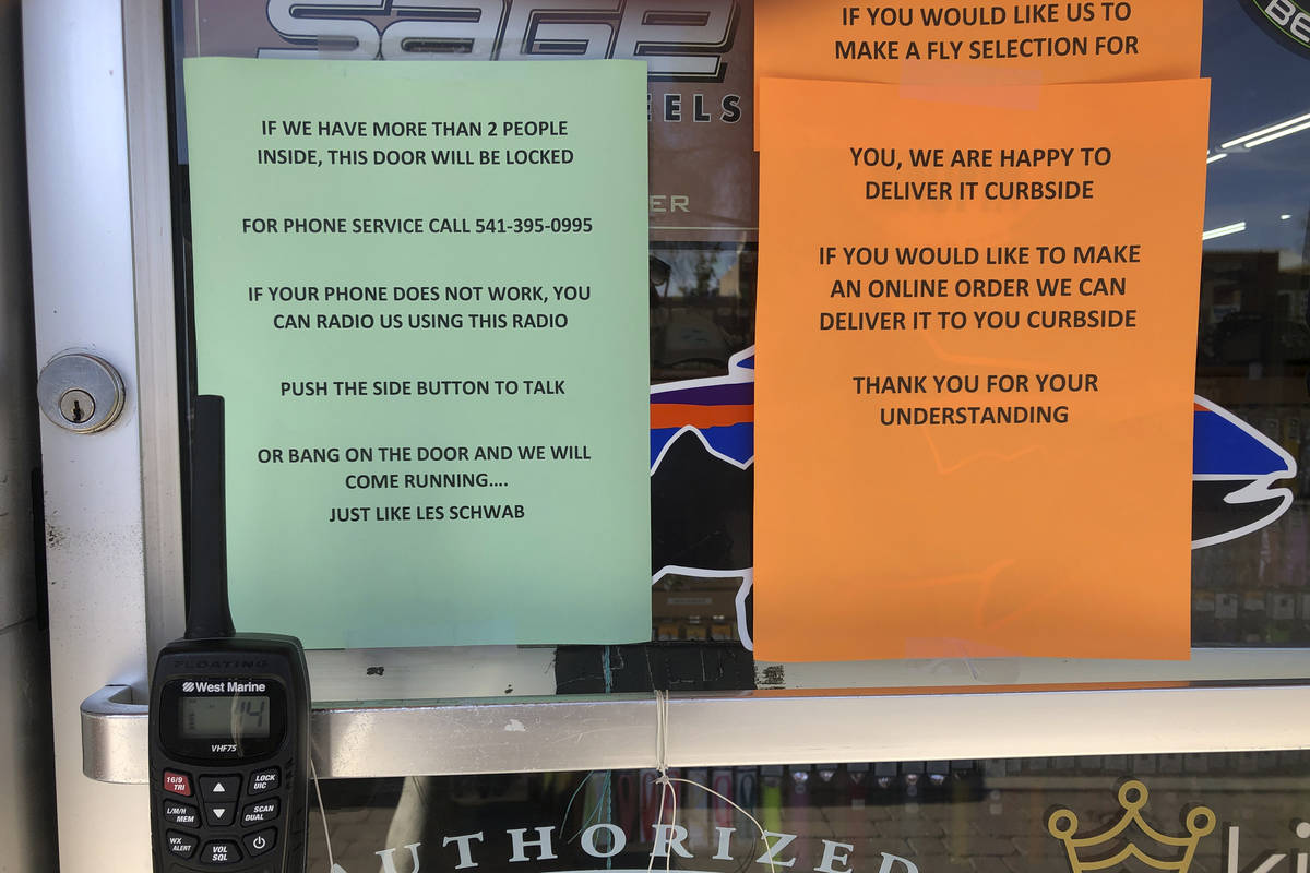 A sign outside a fly fishing shop in tiny Maupin, Oregon, advises customers of new policies to ...