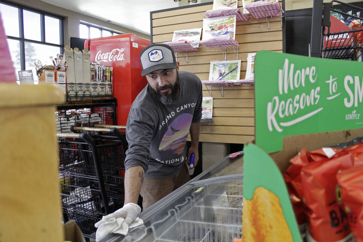 Mike Johnston, a clerk at the Maupin Market in tiny Maupin, Oregon, wipes down the ice cream ca ...