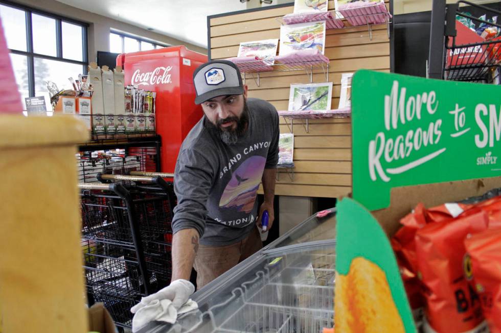 Mike Johnston, a clerk at the Maupin Market in tiny Maupin, Oregon, wipes down the ice cream ca ...
