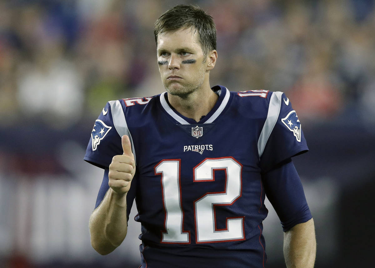 FILE - In this Aug. 16, 2018, file photo, New England Patriots quarterback Tom Brady signals a ...
