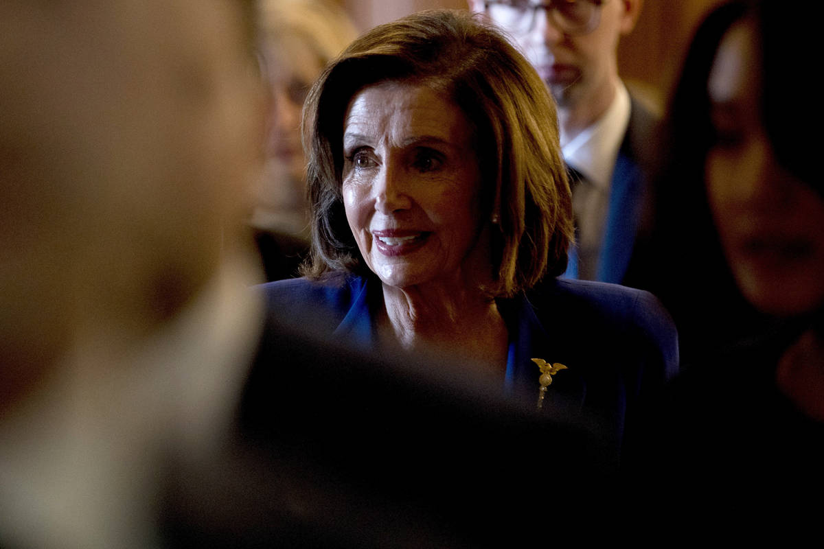 House Speaker Nancy Pelosi of Calif., walks to her office after signing the Coronavirus Aid, Re ...