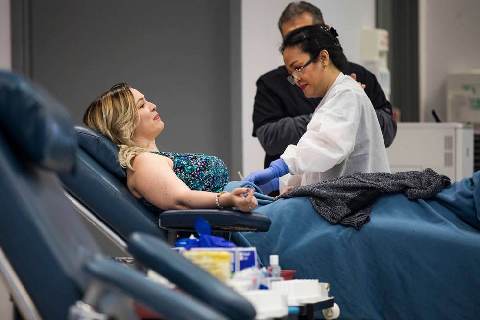Donor Care Technician Lourdes Ambrocio, right, prepares Mary Beth Atanasiu, left, to give blood ...