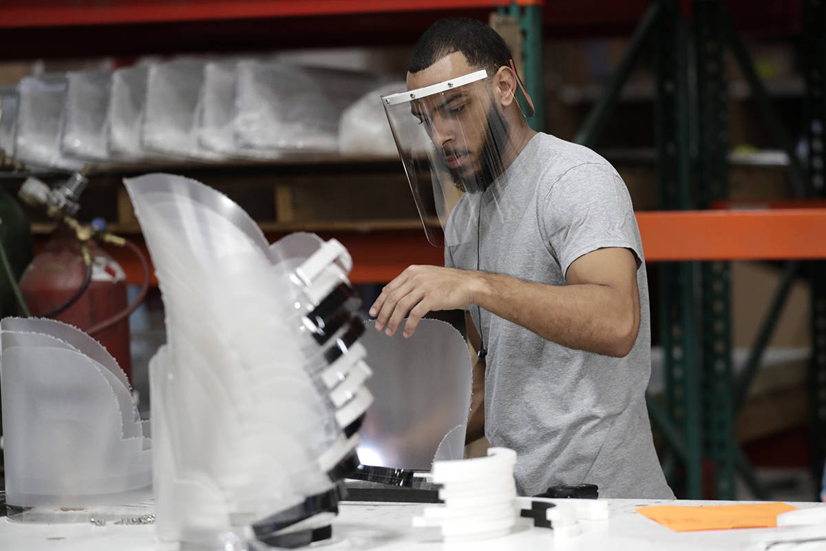 Jonathon Pedrosa, an employee at Faulkner Plastics, assembles plastic face shields used for inf ...