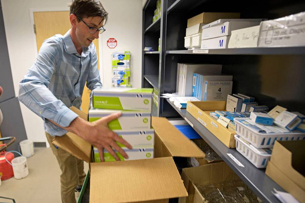 Loyola University professor Dr. CJ Stephenson packs boxes of protective gloves from the Chemist ...