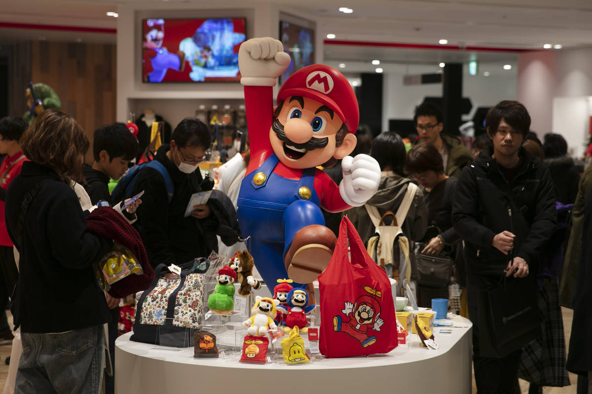 In this Jan. 23, 2020, photo, a Super Mario figure is on display as people shop at Nintendo's o ...