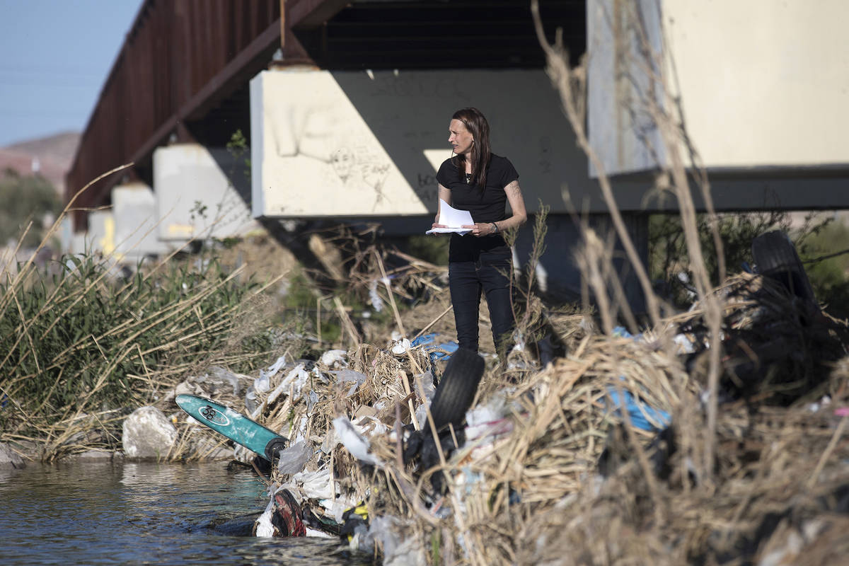 Wendy Cox looks through debris under a bridge at Clark County Wetlands Park looking for her par ...