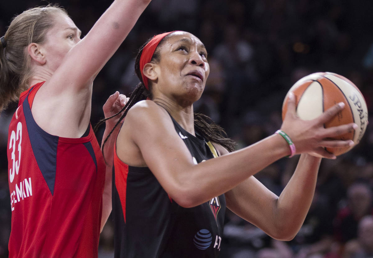 Las Vegas Aces center A'ja Wilson (22) drives past Washington Mystics center Emma Meesseman (33 ...