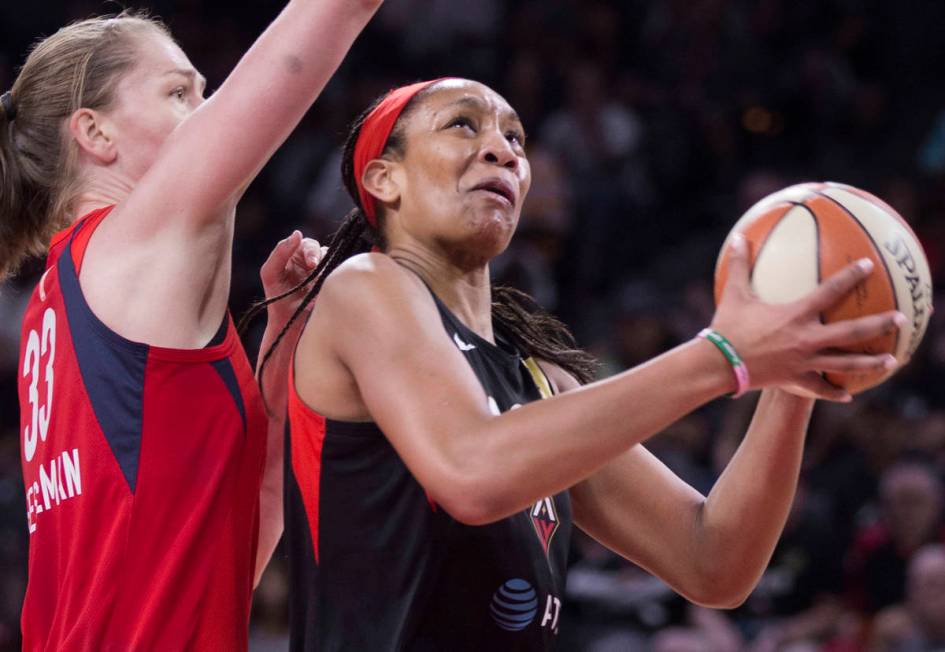 Las Vegas Aces center A'ja Wilson (22) drives past Washington Mystics center Emma Meesseman (33 ...