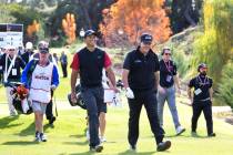 Tiger Woods, left, and Phil Mickelson walk to the fairway after teeing off from the first durin ...