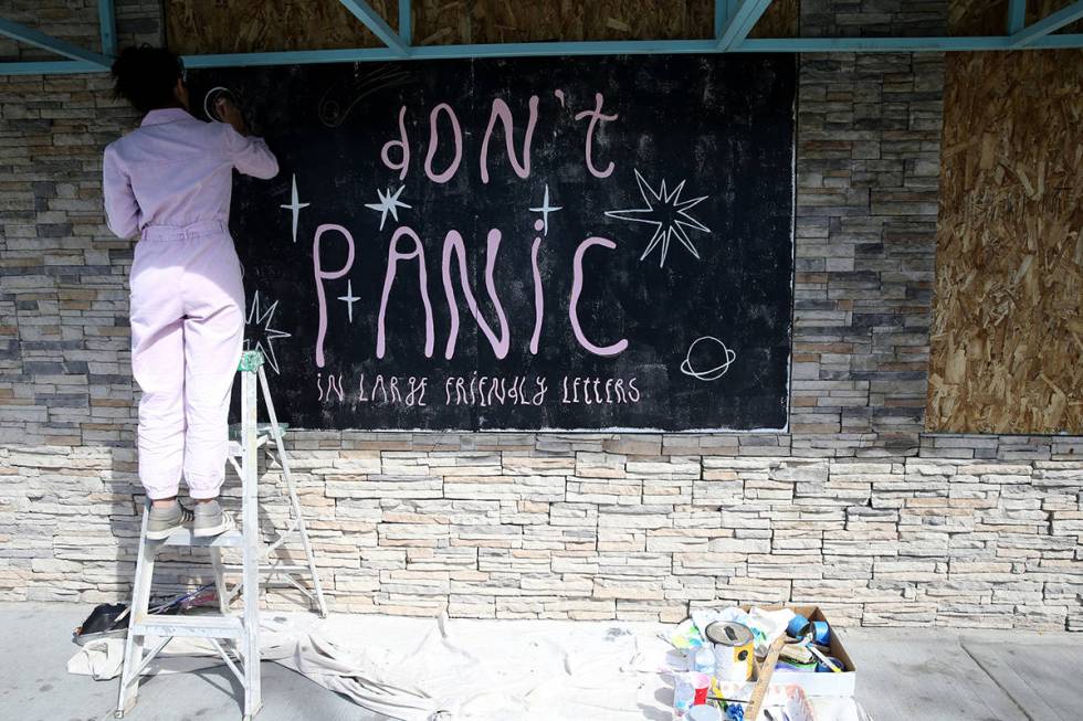 Artist Mila May paints her mural on a boarded up window of Retro Vegas on Main Street in downto ...