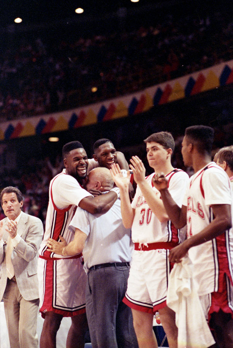 UNLV Rebels player Mosses Scurry and David Butler hug head coach Jerry Tarkanian after winning ...