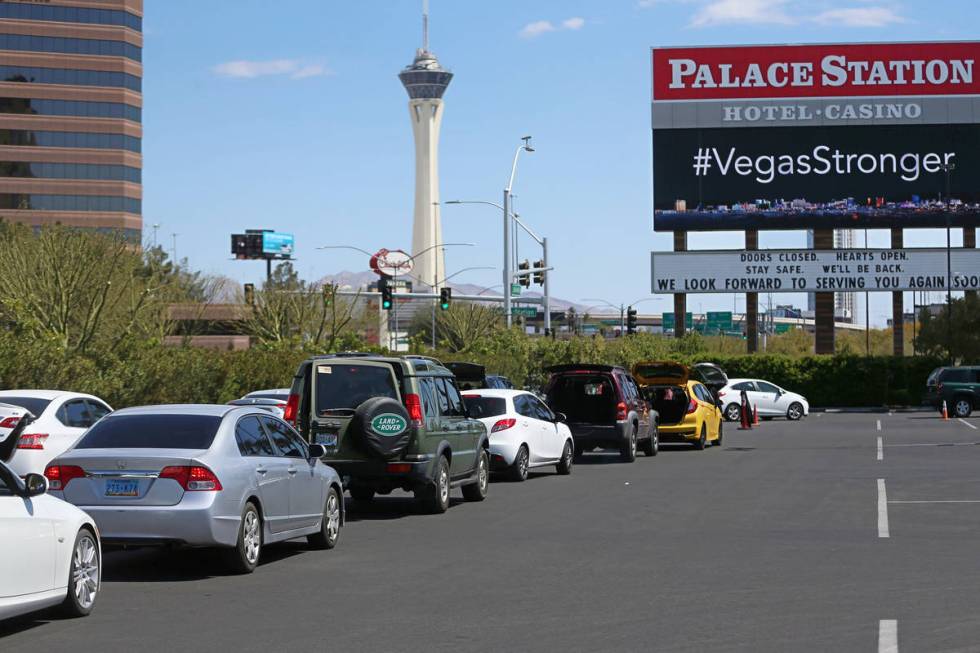 Hundreds of people in their vehicles wait to receive food from Three Square Food Bank at Palace ...